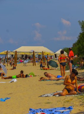 Jurmala, Letonya - 29 Temmuz 2018: İnsanlar Letonya 'nın Jurmala tatil beldesindeki Baltık Körfezi plajında güneşli bir bahar gününün tadını çıkarıyorlar.