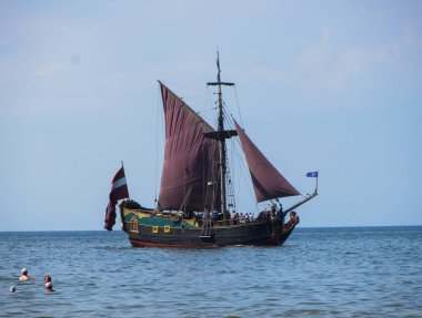 Güneşli sahil, mavi su ve Riga Körfezi kıyısında bir eğlence teknesi. 29 Temmuz 2018, Letonya, Jurmala.