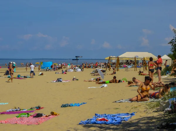 Jurmala, Letonia - 29 de julio de 2018: La gente disfruta del soleado día de primavera en la playa del golfo del mar Báltico en Jurmala resort, Letonia . — Foto de Stock