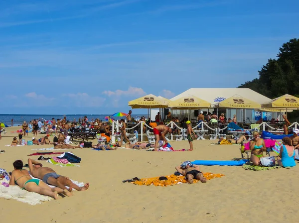 Jurmala, Letonya - 29 Temmuz 2018: İnsanlar Letonya 'nın Jurmala tatil beldesindeki Baltık Körfezi plajında güneşli bir bahar gününün tadını çıkarıyorlar. — Stok fotoğraf