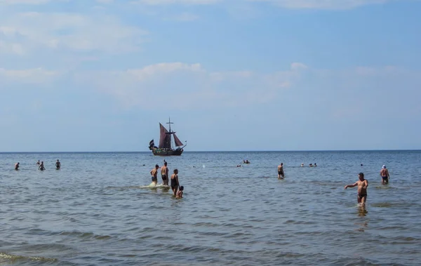 Playa soleada y agua azul y un barco de recreo en la orilla del Golfo de Riga. 29, julio de 2018, Letonia, Jurmala . — Foto de Stock