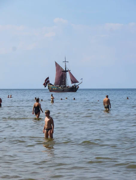 Солнечный берег и голубая вода и прогулочная лодка на берегу Рижского залива. 29, Июль, 2018, Латвия, Юрмала . — стоковое фото