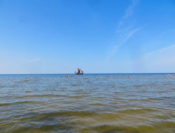 Spiaggia soleggiata e acqua blu e una barca da diporto sulla riva del Golfo di Riga. 29, luglio, 2018, Lettonia, Jurmala . — Foto Stock