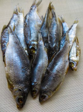 Masada kurutulmuş balık var. Koyu ahşap arka planda tuzlu, kuru nehir balığı..