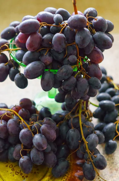 Aglomerados de uvas frescas doces e escuras deitadas sobre a mesa . — Fotografia de Stock