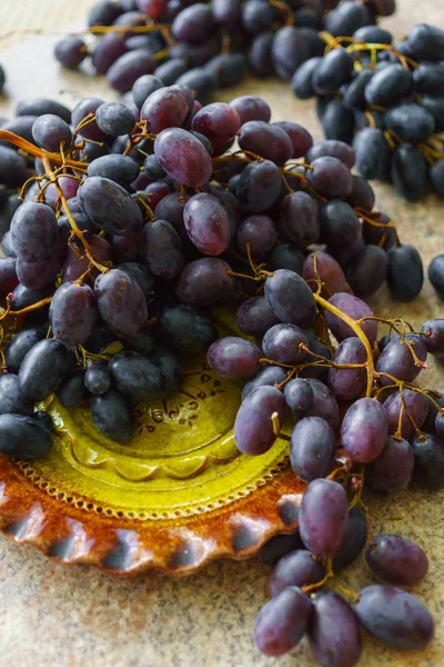 Aglomerados de uvas frescas doces e escuras deitadas sobre a mesa . — Fotografia de Stock