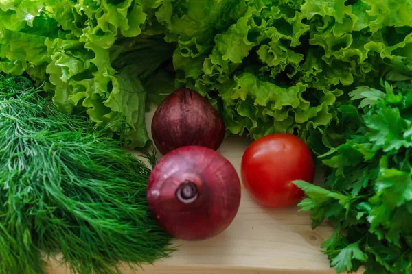 Schönes grünes Gemüse mit Gurken und roten Tomaten und Zwiebeln. — Stockfoto