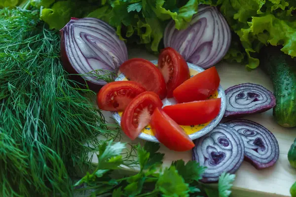 Hermosas verduras verdes con pepinos y tomates rojos picados y cebollas . — Foto de Stock