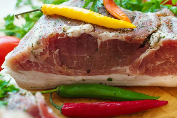 Piece of pork salted in the traditional way, along with chili. — Stock Image Piece of pork salted in the traditional way, along with chili. Royalty Free Stock Photos