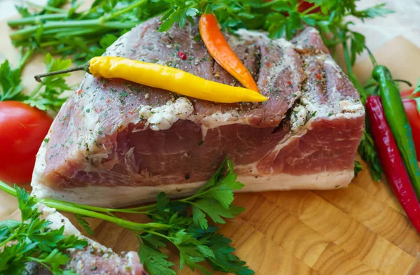 Piece of pork salted in the traditional way, along with chili. — Stock Image Piece of pork salted in the traditional way, along with chili. Stock Picture