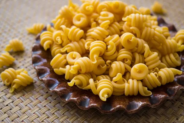 Pasta hecha de harina, esparcida en un plato, sobre una mesa . —  Fotos de Stock