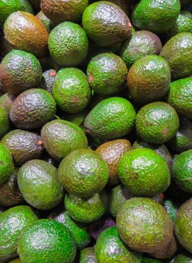 Mağazadaki rafta bir kutu olgun avokado meyvesi var..