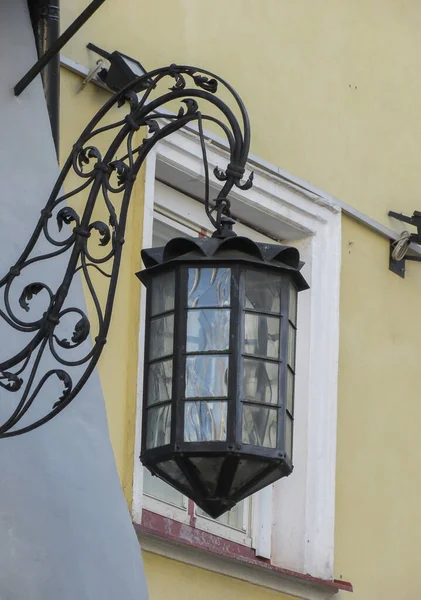 Tallinn 'de bir evin duvarında eski bir sokak lambası.