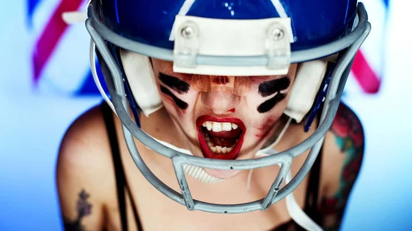  Bir maske ve kask giymiş kız ve Amerikan futbol