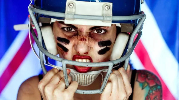 Girl and American football, wearing a mask and helmet