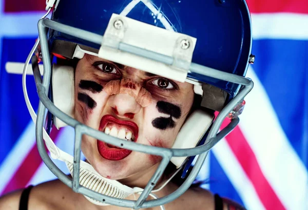 Girl and American football, wearing a mask and helmet