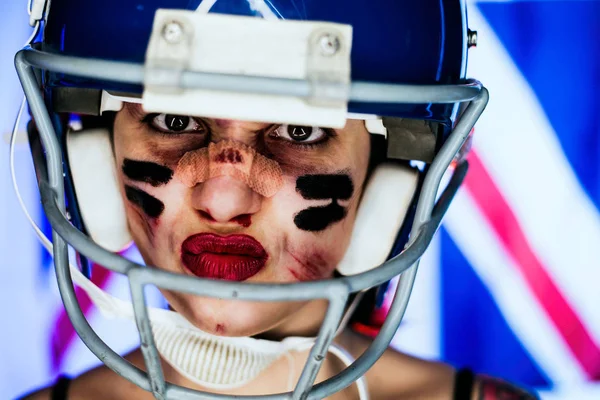 Girl and American football, wearing a mask and helmet