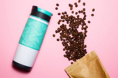 Dökülen kahve ve pembe bir arka plan üzerinde bir termometre