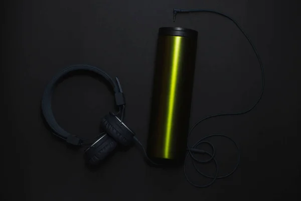 Thermocup ve siyah bir arka plan üzerinde kulaklık