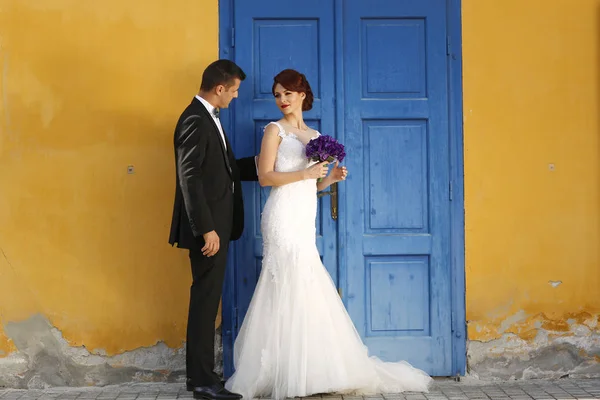 Beau couple nuptial à côté de mur coloré et porte — Photo