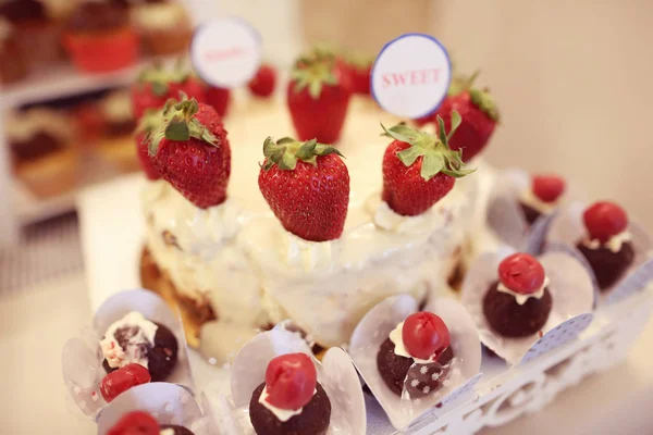 Leckere Süßigkeiten und Erdbeerkuchen — Stockfoto