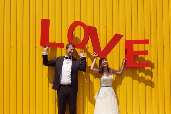 Mariée et marié s'amuser avec des lettres d'AMOUR — Photo