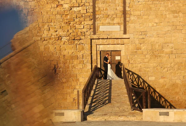 Невеста и жених целуются возле замка — стоковое фото
