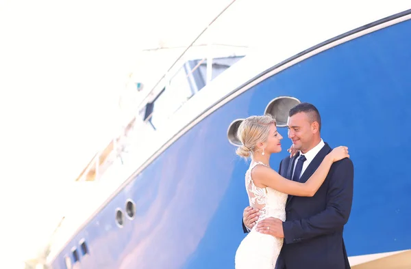 Joyful brudparet embracing nära båtar — Stockfoto