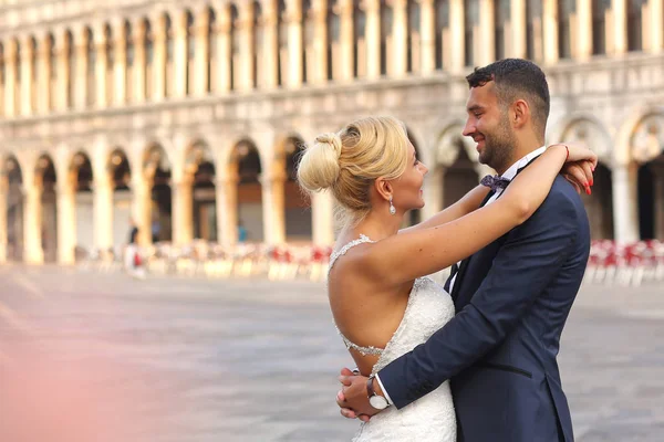 Bruden och brudgummen poserar i staden — Stockfoto