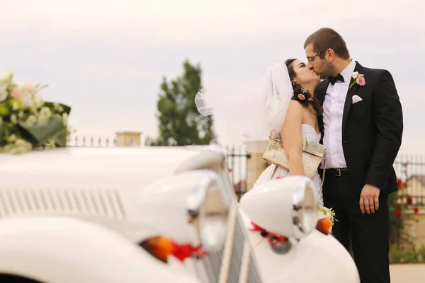 Novia y novio abrazando cerca de coche retro —  Fotos de Stock