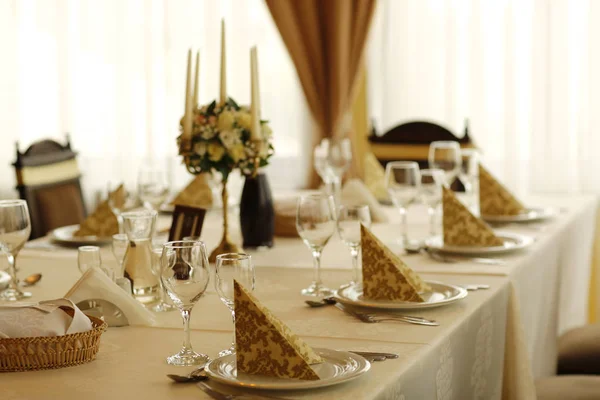 Elegante mesa de jantar com buquê de flores e decorações de velas — Fotografia de Stock