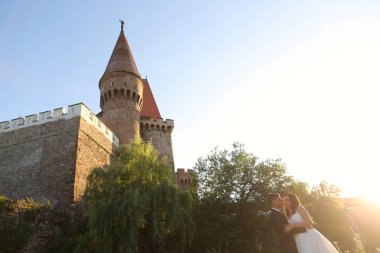 Gelin ve damat Ortaçağ Kalesi gece karanlığında kucaklayan