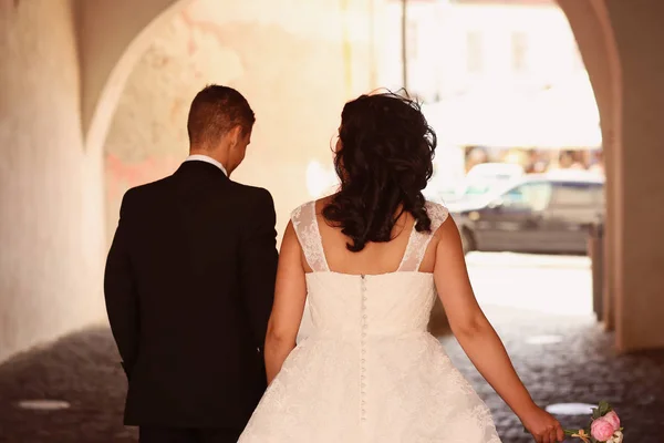 Back of the bride and groom walking in old street — Stock Photo, Image