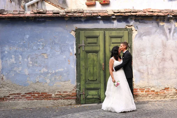 Novia y novio abrazando cerca de casa vieja —  Fotos de Stock