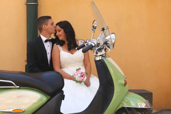 Hermosa pareja nupcial abrazando cerca de scooter vintage —  Fotos de Stock