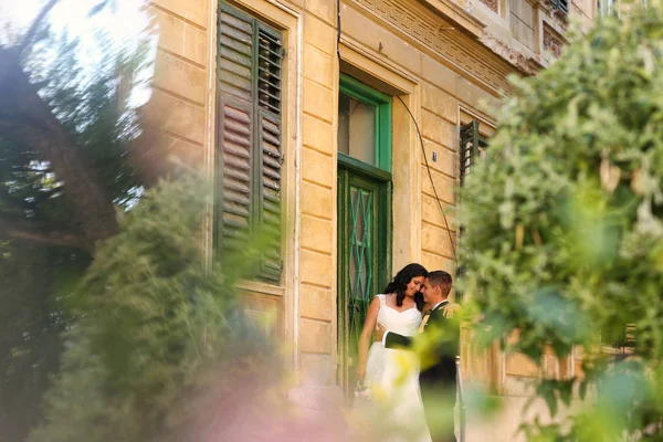 Bride and groom embracing near old house — Stock Photo, Image