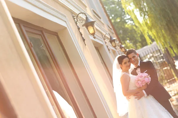 Bruden och brudgummen embracing utomhus — Stockfoto