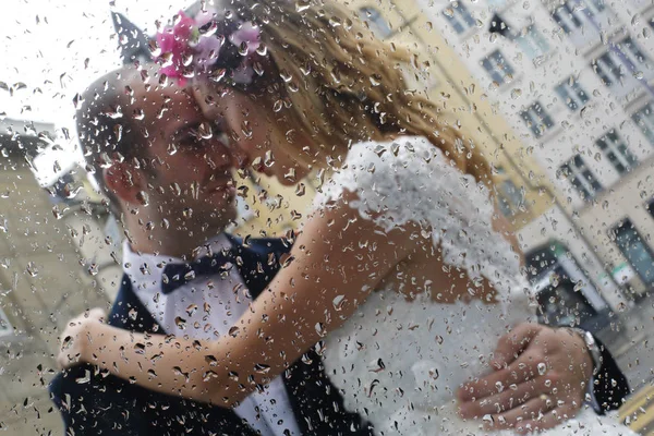 Beautiful bride and groom embracing in rain — Stock Photo, Image