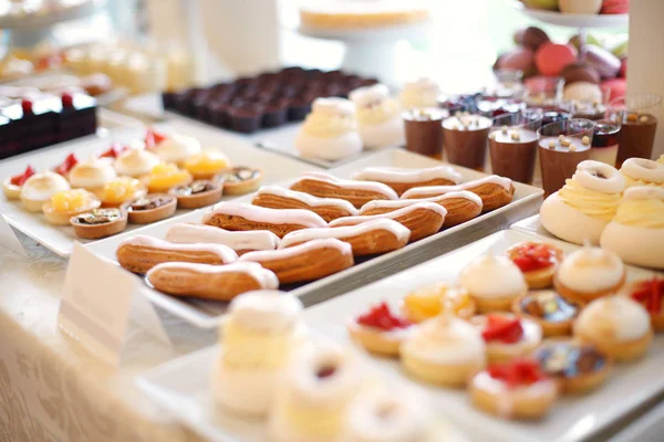 Table full with mini cakes and sweets — Stock Photo, Image