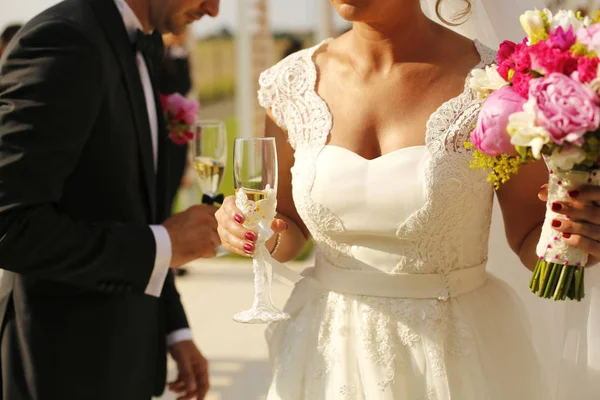 Gorgeous bride and groom holding glasses — Stock Photo, Image