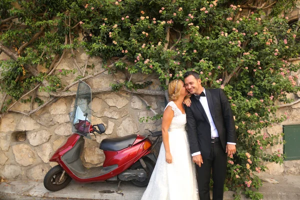 Couple nuptial posant près d'un scooter rouge — Photo