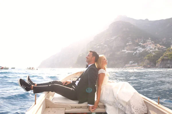 Gorgeous bride and groom in a wooden boat — Stock Photo, Image