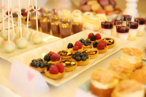 Mesa con deliciosos mini pasteles —  Fotos de Stock