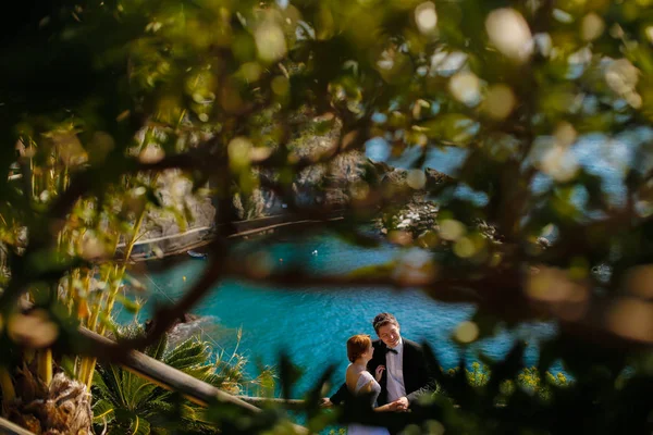 Sposo e sposa sulle rocce in riva al mare — Foto Stock