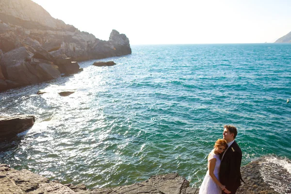 Vőlegény és a menyasszony a sziklák, a tenger — Stock Fotó