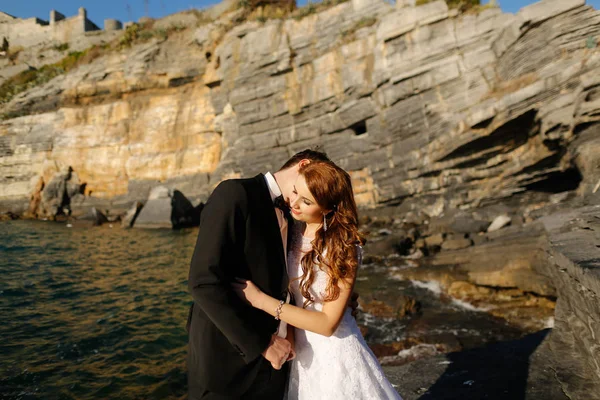 Novio y novia en las rocas junto al mar —  Fotos de Stock