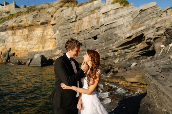 Groom and bride on the rocks by the sea — Stock Photo, Image