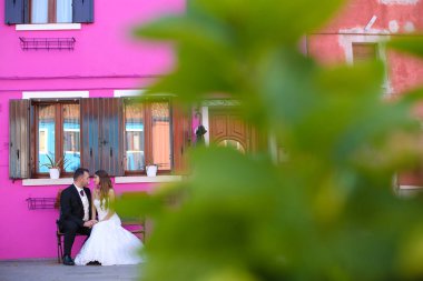 Damat ve gelin mor bir evin önünde