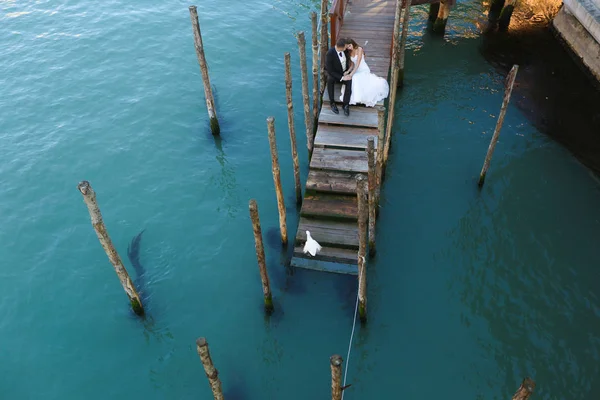 Novio y novia en una cubierta cerca del agua —  Fotos de Stock