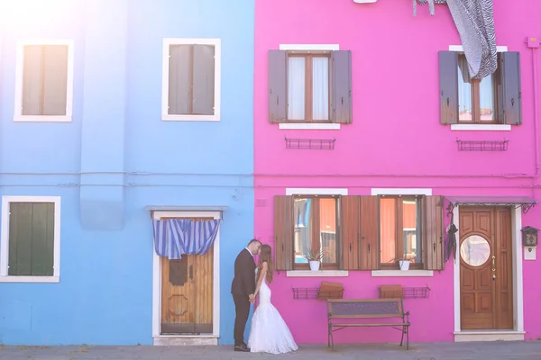 Sposo e sposa di fronte a una casa blu e viola — Foto Stock